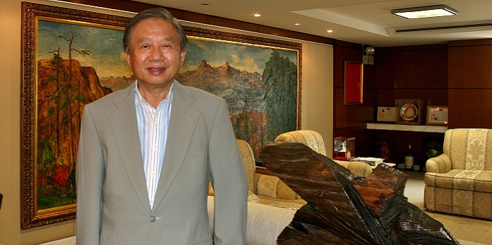 洪敏弘及其藝術收藏。右為朱銘「太極系列」木雕作品，後方為楊三郎作品。