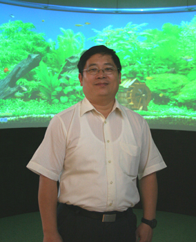 宜昇科技副總經理蔡育良，背景為該公司的曲面投影展示牆。（攝影／游崴）